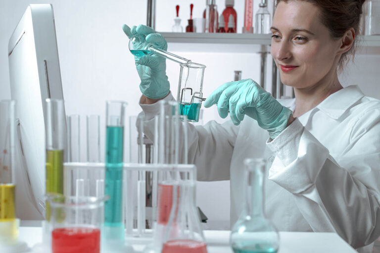 Active woman scientist pouring liquid into beakers in a chemical laboratory.. Lifestyle outdoor scene
