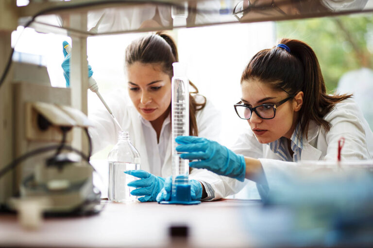 Two young female scientist doing experiments in lab.